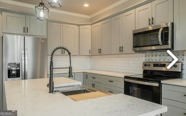 a kitchen with stainless steel appliances a stove microwave and sink