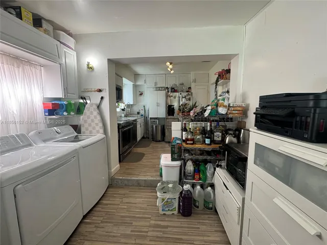 a view of a kitchen with fridge and workspace
