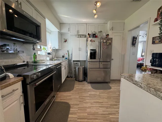 a kitchen with stainless steel appliances granite countertop a stove a refrigerator and a microwave