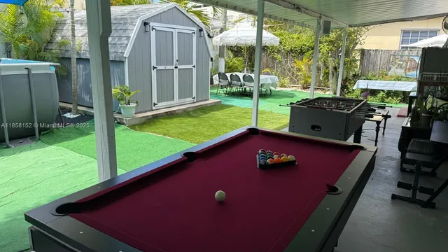 a view of a backyard with table and chairs and potted plants