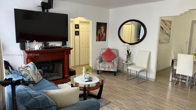 a living room with furniture a flat screen tv and a fireplace