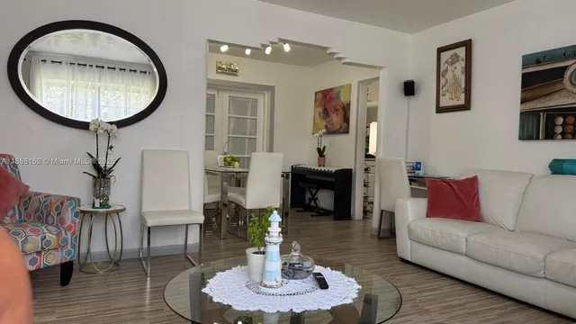 a living room with furniture a mirror and a chandelier