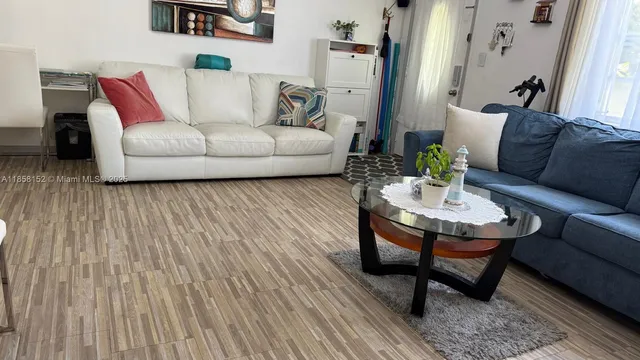 a living room with furniture and a wooden floor