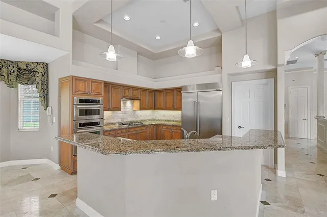 a kitchen with stainless steel appliances granite countertop a sink a oven and a refrigerator