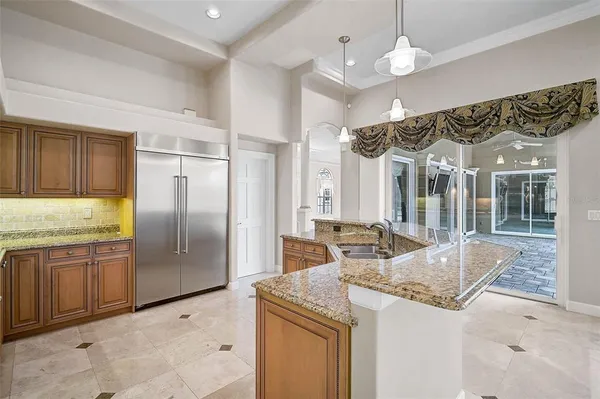 a kitchen with granite countertop a sink and refrigerator