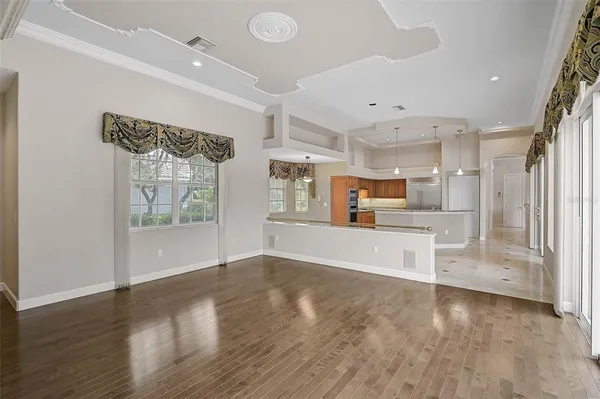a view of a kitchen with refrigerator and wooden floor