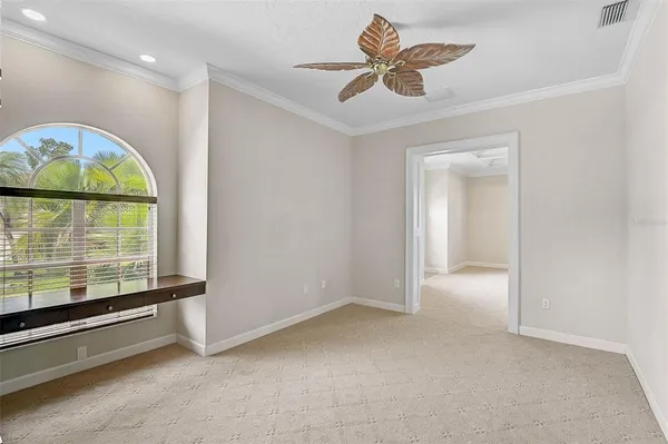 an empty room with windows and ceiling fan