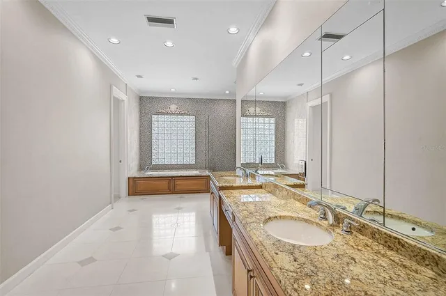 a bathroom with a granite countertop tub sink and mirror