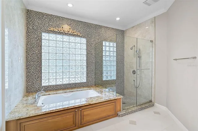 a spacious bathroom with a granite countertop tub shower and mirror