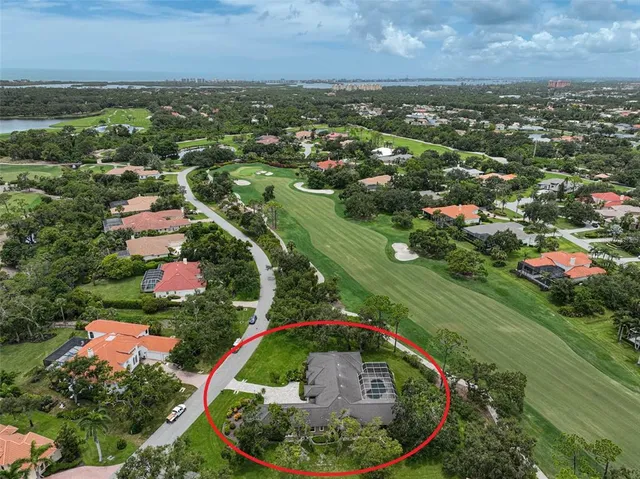 an aerial view of residential houses with outdoor space and trees