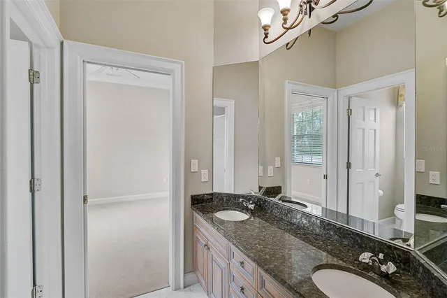 a bathroom with a granite countertop sink a mirror and a shower