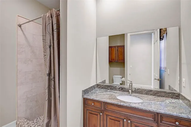 a bathroom with a granite countertop sink and a mirror