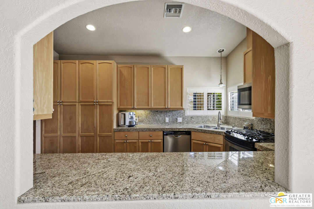 35127 Plumley Road Cathedral City, CA 92234 - Photo 12 of 32 a kitchen with kitchen island granite countertop a sink and cabinets