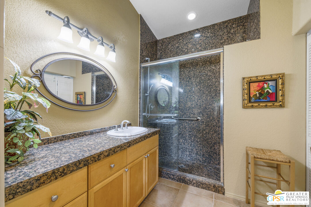 35127 Plumley Road Cathedral City, CA 92234 - Photo 18 of 32 a bathroom with a granite countertop sink a mirror and a shower