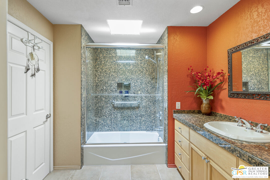 35127 Plumley Road Cathedral City, CA 92234 - Photo 21 of 32 a bathroom with a granite countertop sink a mirror a bathtub and shower