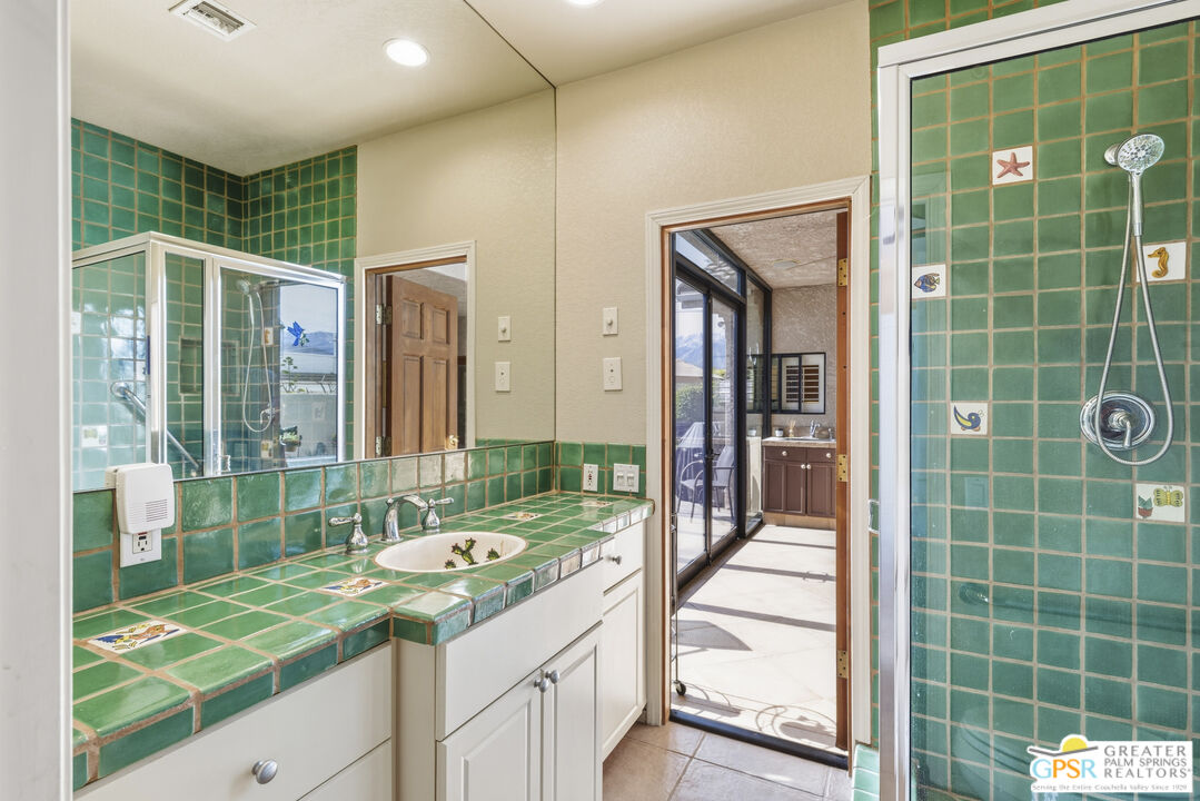 35127 Plumley Road Cathedral City, CA 92234 - Photo 26 of 32 a bathroom with a shower sink and mirror