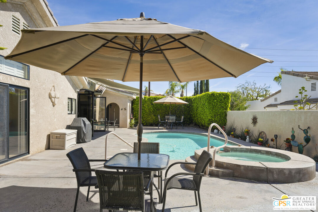 35127 Plumley Road Cathedral City, CA 92234 - Photo 29 of 32 a backyard of a house with table and chairs under an umbrella