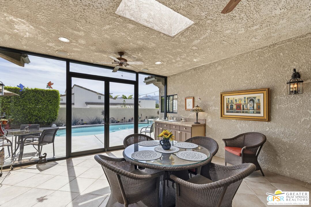 35127 Plumley Road Cathedral City, CA 92234 - Photo 7 of 32 a view of a dining room with furniture large windows and wooden floor