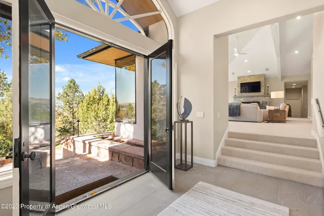 a living room with furniture and a floor to ceiling window