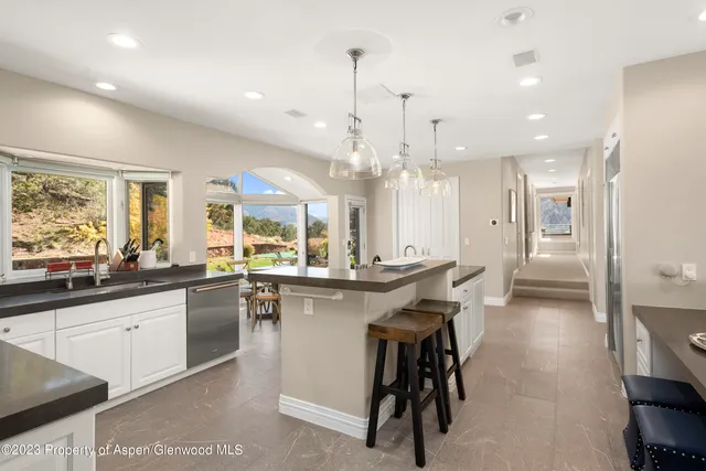a kitchen with stainless steel appliances granite countertop a sink a stove a refrigerator and island