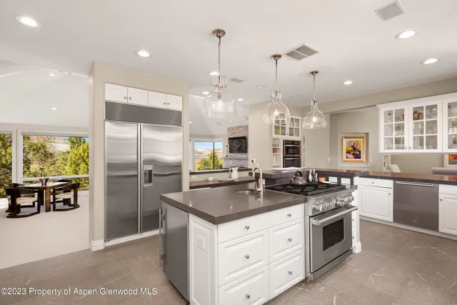 a view of a city from a dining room with a table and chairs
