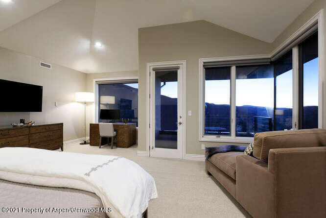 571 Booth Lane Basalt, CO 81621 - Photo 31 of 58 a bedroom with a balcony a bed and a flat screen television
