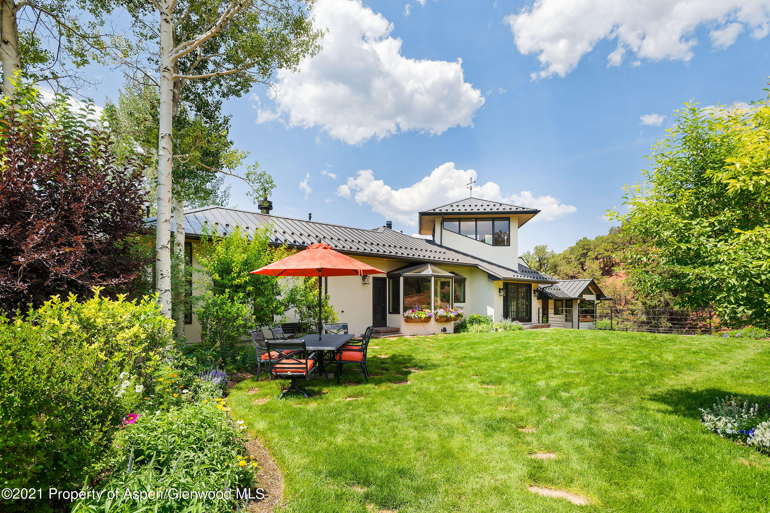 571 Booth Lane Basalt, CO 81621 - Photo 8 of 58 a view of a white house with a big yard and potted plants