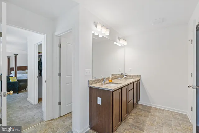 a bathroom with a granite countertop sink a large mirror and a shower