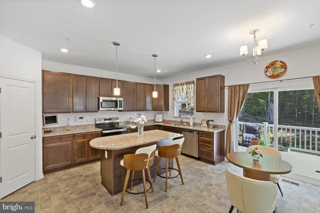 a kitchen with a sink a stove a refrigerator and chairs