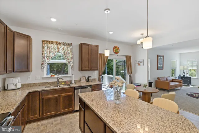 a kitchen with granite countertop a sink a counter space appliances and cabinets