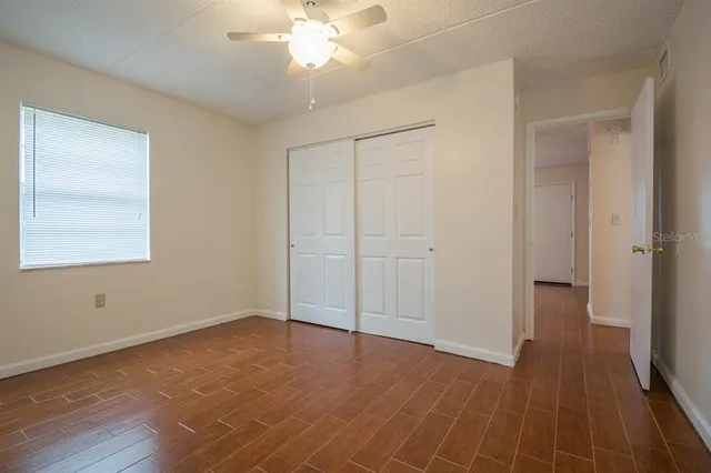 a view of an empty room with wooden floor