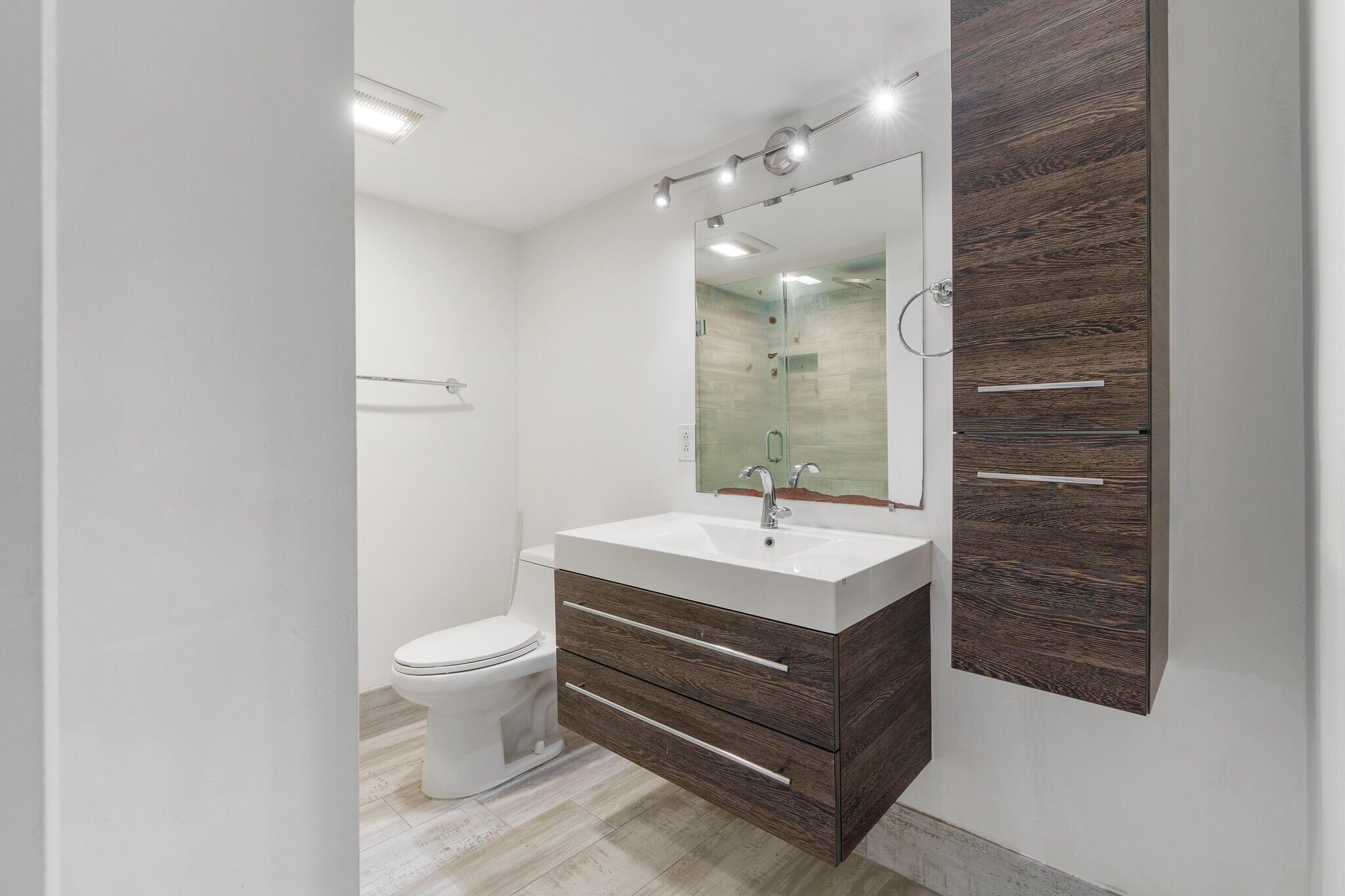 951 De Soto Road, Unit 130 Boca Raton, FL 33432 - Photo 14 of 38 a bathroom with a sink a toilet and a mirror