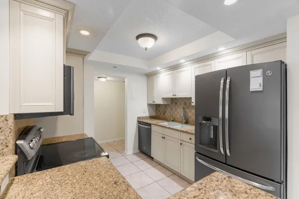 a kitchen with granite countertop a refrigerator and a sink