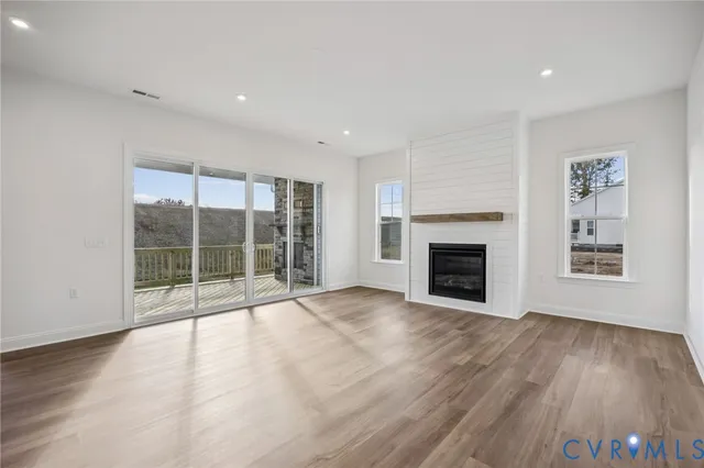 a view of an empty room with a fireplace and a window