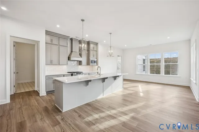 a large kitchen with kitchen island a sink stainless steel appliances and cabinets
