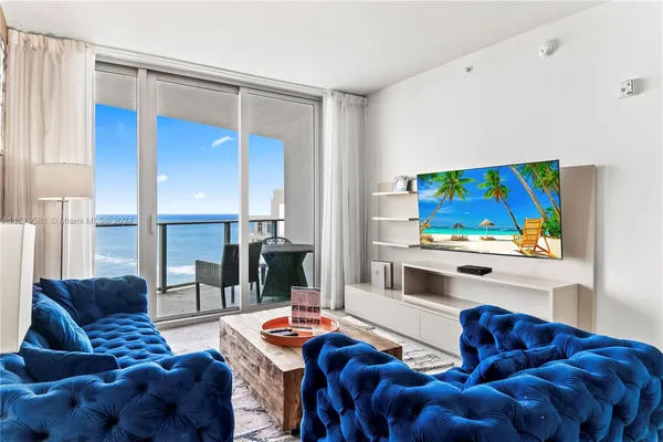 a living room with furniture a rug and a painting on the wall