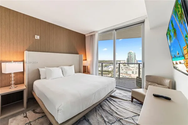 a bedroom with a bed couch and a large window