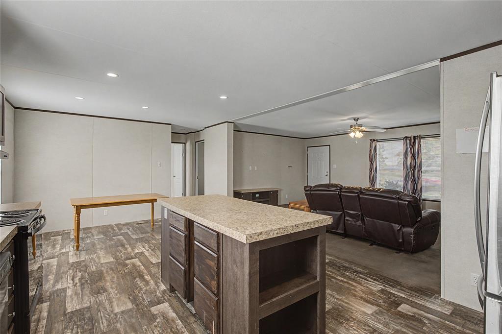 177 New Highland Road Springtown, TX 76082 - Photo 13 of 40 Spacious kitchen island with a light-toned countertop and dark wood-finish cabinetry