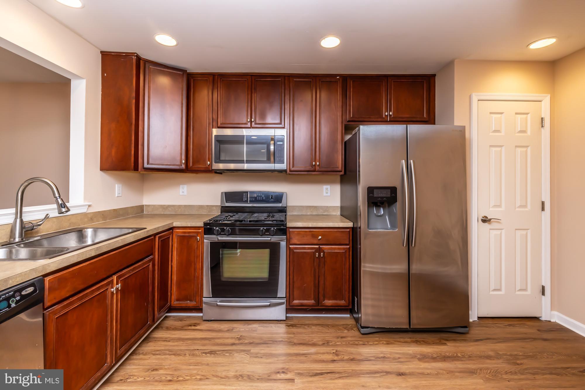 253 Flagstone Road, Unit 7 Chester Springs, PA 19425 - Photo 7 of 32 a kitchen with stainless steel appliances granite countertop a refrigerator stove and sink