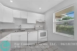 a kitchen with granite countertop a sink and cabinets