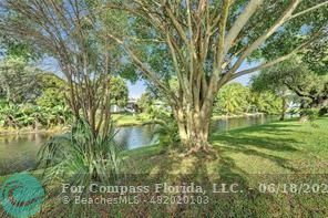 7605 Northwest 5th Place, Unit 101 Margate, FL 33063 - Photo 4 of 14 a backyard of a house with lots of green space and fountain