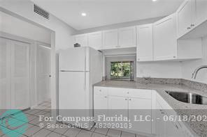 7605 Northwest 5th Place, Unit 101 Margate, FL 33063 - Photo 10 of 14 a kitchen with a white cabinets and window