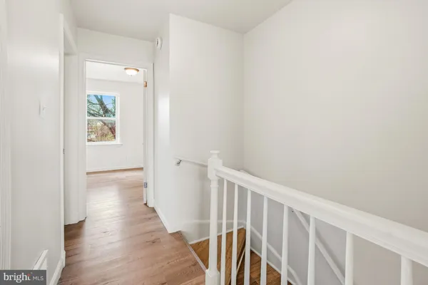 a view of a hallway with wooden floor and entryway