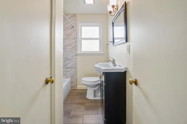 a bathroom with a granite countertop toilet a sink and a mirror