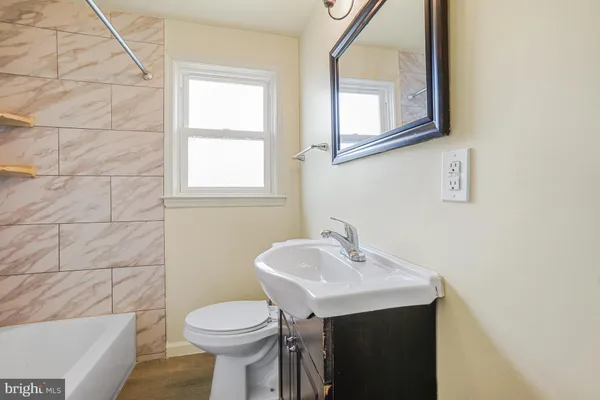 a bathroom with a sink a toilet and mirror