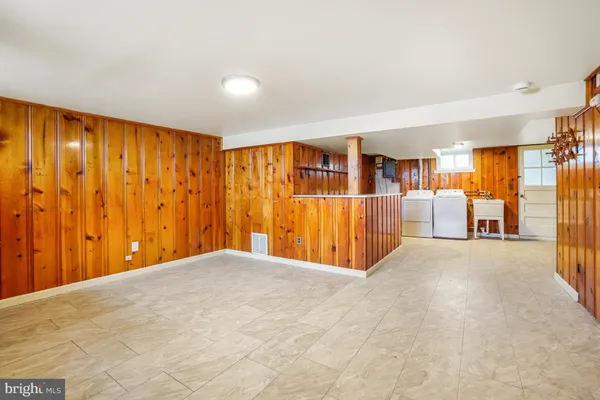 a view of an empty room with wooden floor and windows