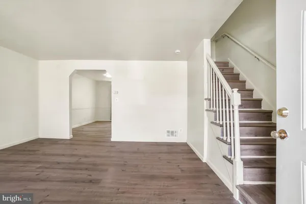 a view of a hallway with wooden floor and entryway