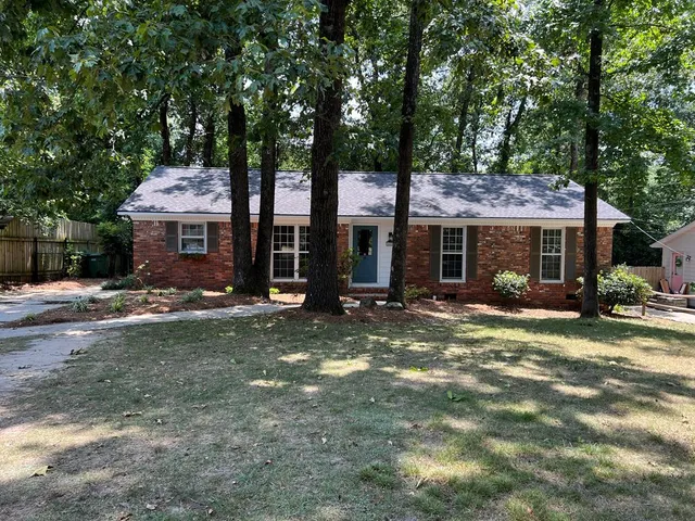 a view of a house with backyard and sitting area
