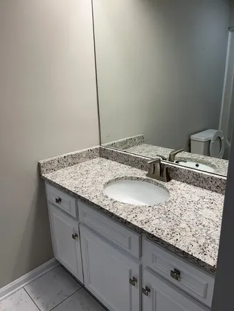 a bathroom with a granite countertop sink and vanity