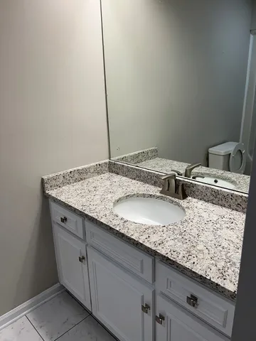 a bathroom with a granite countertop sink and vanity